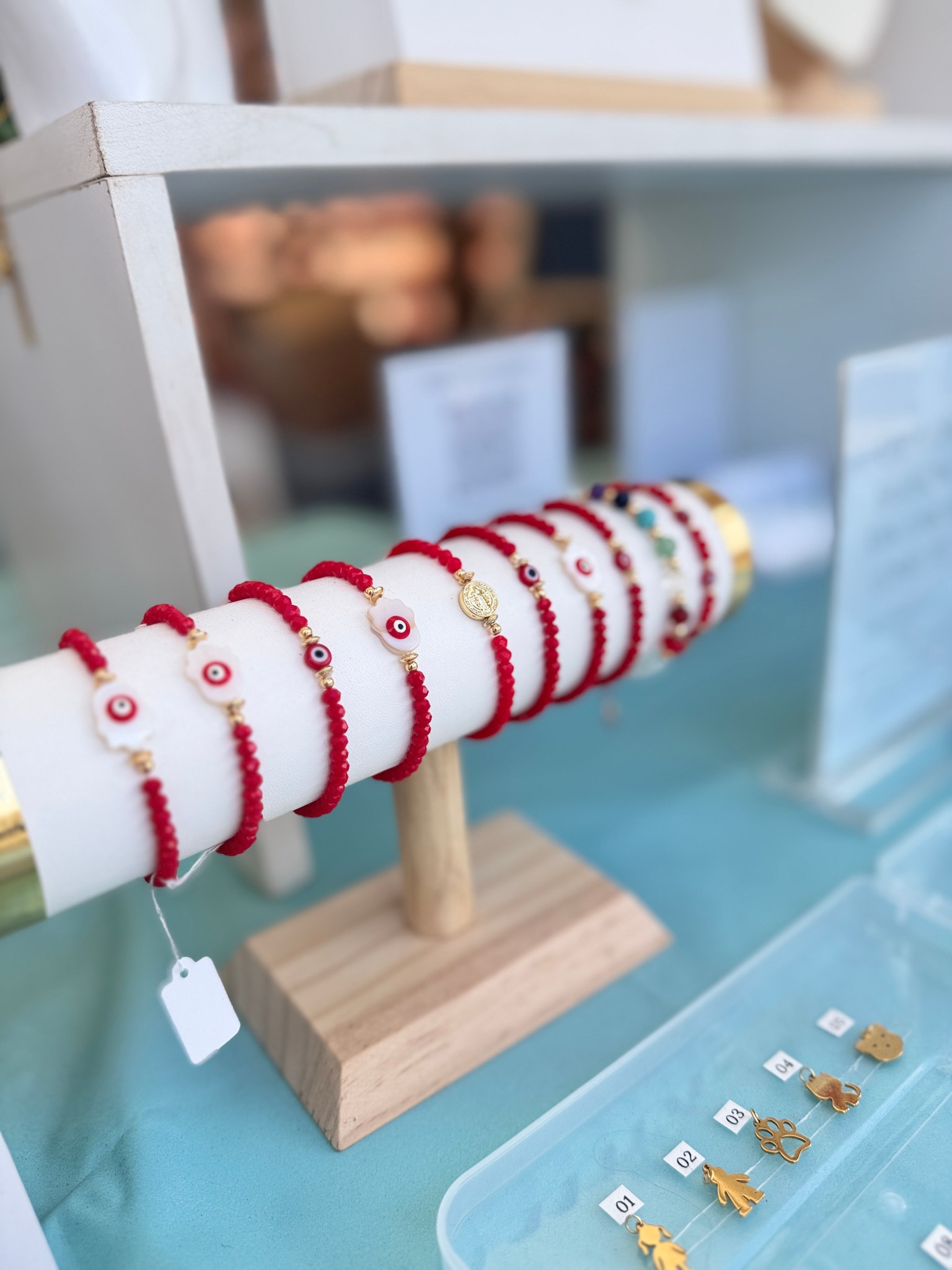 Colección de brazaletes rojos con dijes dorados Caprichos